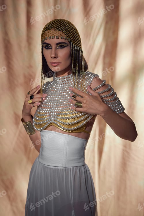 Preview: Woman in traditional egyptian headdress, pearl top and look posing on abstract background
