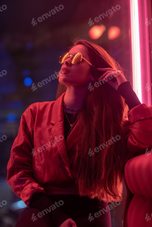 Preview: Portrait of young woman with long black hair and red leather jacket with neon pink lights