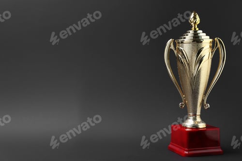 Preview: Golden trophy cup on grey background. Space for text