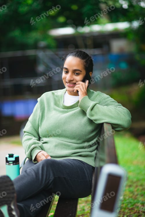 Preview: young latin woman sitting in a van while talking on the phone
