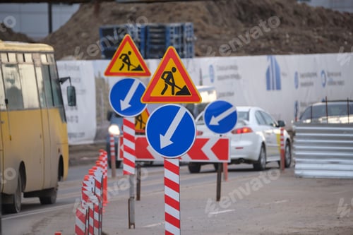 Preview: Roadworks warning traffic signs of construction work on city street and slowly moving cars