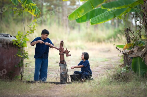 Preview: Childhood in rural Thailand. A small child assists his family by pumping natural water into a bucket