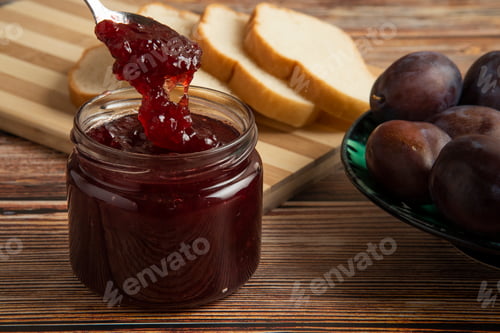 Preview: Plums with a jar of confiture and a toast bread
