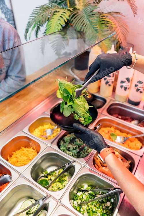 Preview: Woman Adding Ingredients Into Poke Bowl