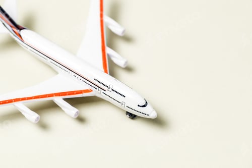 Preview: White toy plane on yellow background. Top view