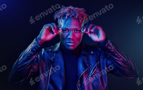 Preview: Having fun. Futuristic neon lighting. Young african american man in the studio