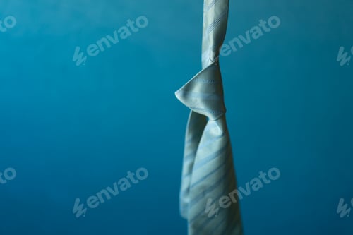 Preview: Hanging light green tie with knot on blue background