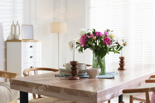 Preview: Dining table with beautiful flowers and dishware in room. Interior design