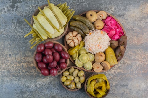 Preview: Salty vegetables in wooden bowls on marble background