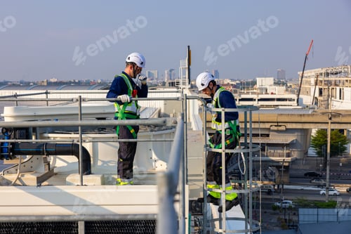 Preview: Industrial Technicians Standing on Rooftop Facility Platform