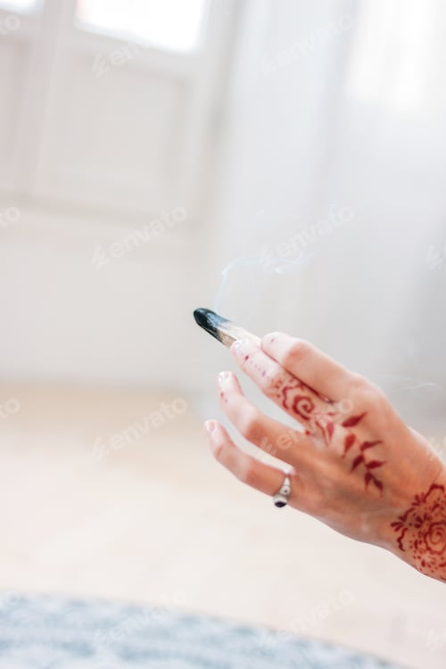 Preview: Palo santo or Bursera graveolens. Blonde young woman holding stick holy wood, close up