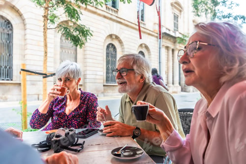 Preview: Senior friends enjoying coffee and conversation at outdoor cafe