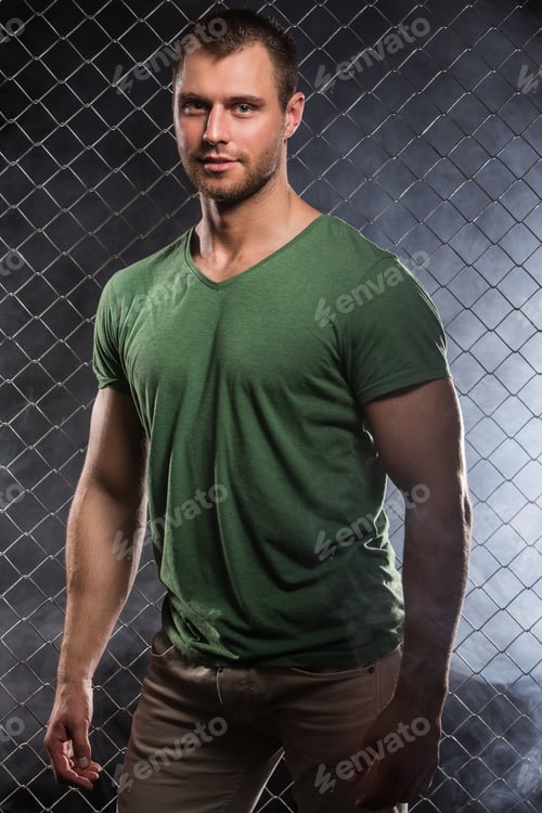 Preview: Fitness. Beautiful, strong man in clothes on fence background