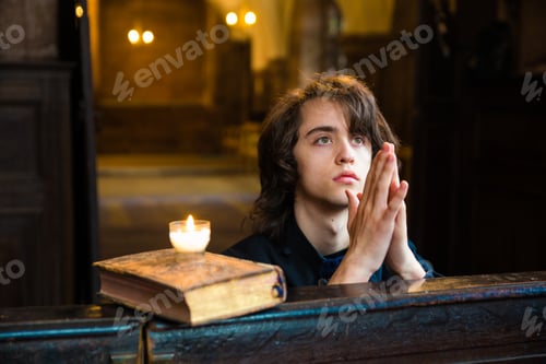Preview: Young boy praying in a church