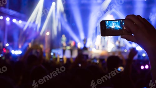 Preview: Fan taking photo of concert
