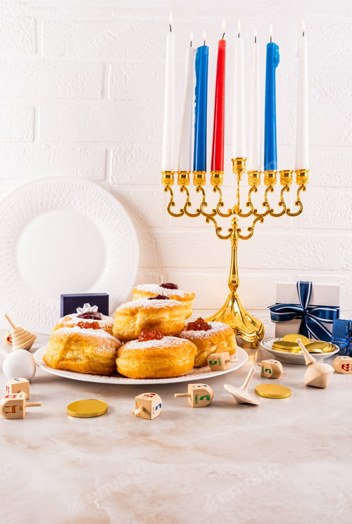 Preview: Traditional symbols, treats on a marble counterto, white brick wall. Burning candles in the menorah.