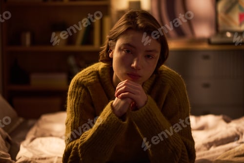 Preview: Portrait of Young Woman Sitting Indoors Looking Contemplative
