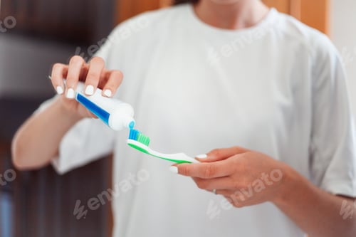 Preview: Woman hands holding toothpaste and toothbrush