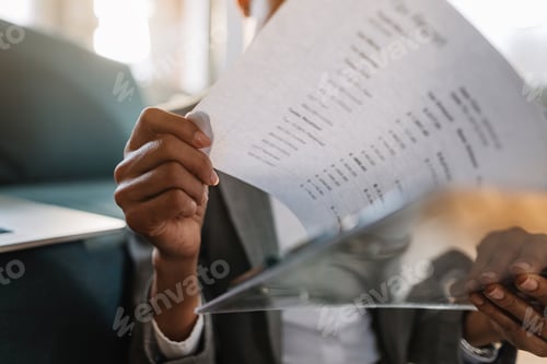 Preview: Close-up of black businesswoman examining reports.