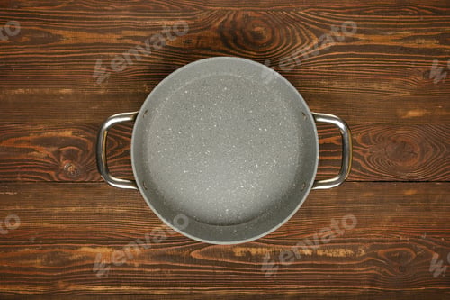 Preview: Nonstick cooking pot on a wooden table ready for meal preparation in a cozy kitchen environment