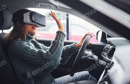 Preview: Side view of woman in virtual reality glasses that sitting inside of modern car
