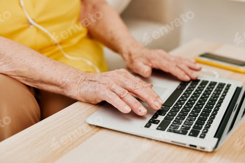 Preview: Cookie elderly woman typing on a modern laptop text close-up hands with a keyboard, online chatting.