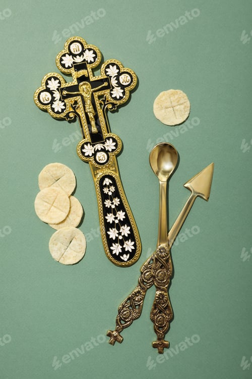 Preview: Bread, cross and cutleries on green background, top view