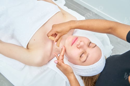 Preview: Woman getting face maderotherapy in a beauty salon. Professional skin care treatment.