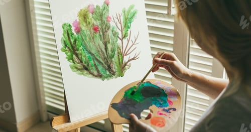 Preview: Female artist painting plants on canvas during spring time - Woman mixing watercolors at home