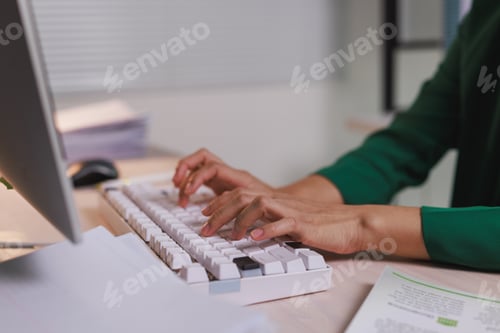 Preview: Person typing on computer keyboard at office desk
