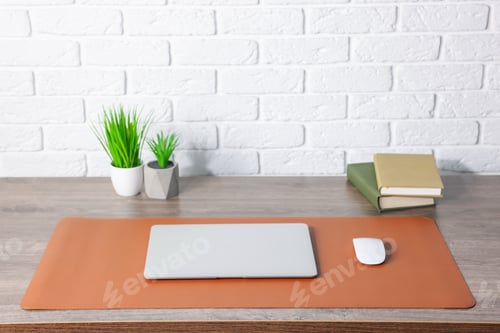 Preview: Stylish workplace with laptop and orange mousepad on wooden table indoors. Space for text