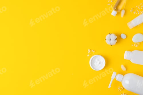 Preview: Cosmetic background with skin care products on yellow. Flat lay, copy space