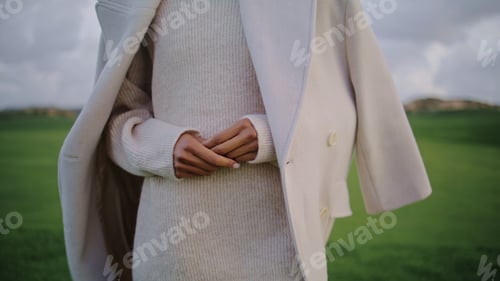 Preview: Closeup anxious woman hands at green field. Nervous girl comforting herself
