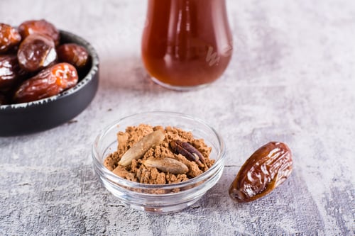 Preview: Bowl with date pit powder for making coffee on the table. Caffeine Free Alternative to Coffee