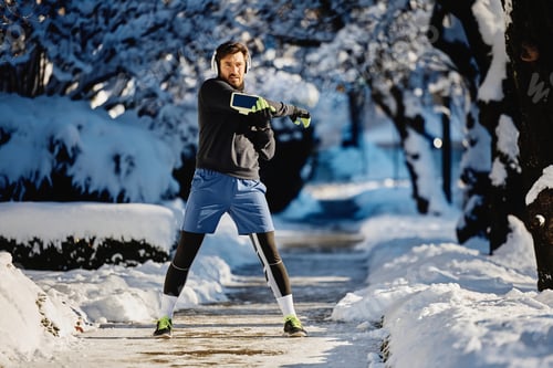 Preview: Determined athlete exercising in snow during winter day at the park.
