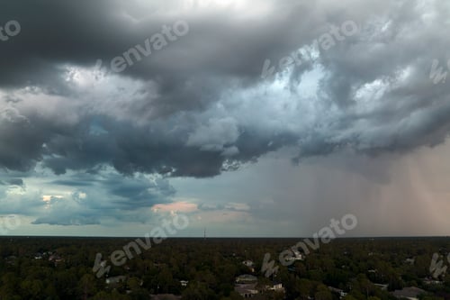 Preview: Dark stormy clouds forming on gloomy sky before heavy rainfall over suburban town area