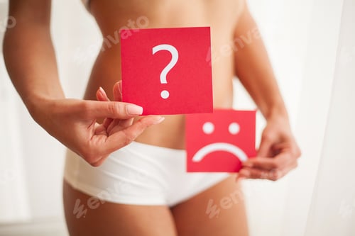 Preview: Female With Fit Slim Body Holding Cards With Sad Smiley Face and Question Mark Near Her Stomach