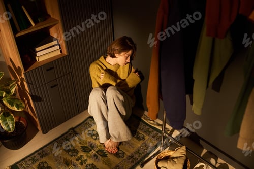 Preview: Young Woman Sitting Alone on Floor Feeling Sad and Isolated