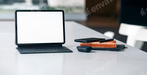 Preview: Creative workspace with laptop computer and supplies on table, blank screen for product display.