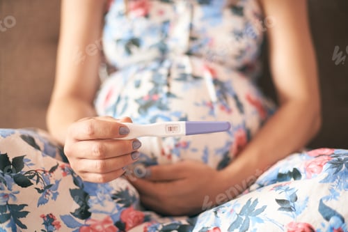 Preview: Closeup of pregnancy test in hands of young woman