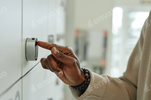 Preview: Male Employee Opening Personal Storage Locker Entering Code on Keypad Indoors
