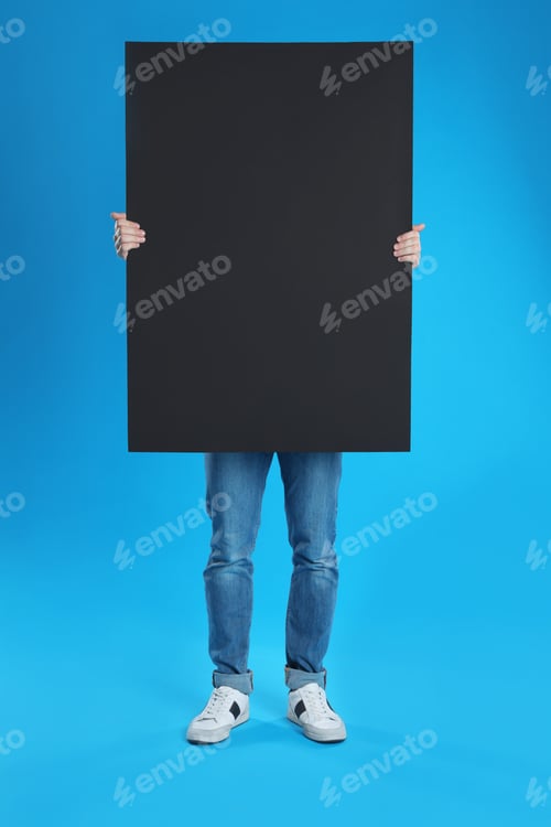 Preview: Man holding blank poster on blue background