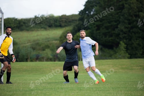 Preview: Football players playing soccer in the ground