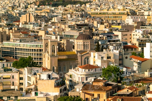 Preview: Golden light washes over a dense cityscape with classic architecture.