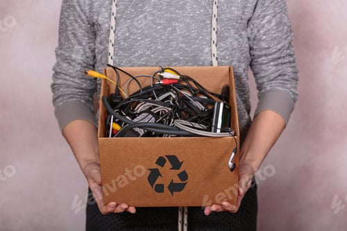 Preview: Female hands carrying cardboard box filled with old digital devices