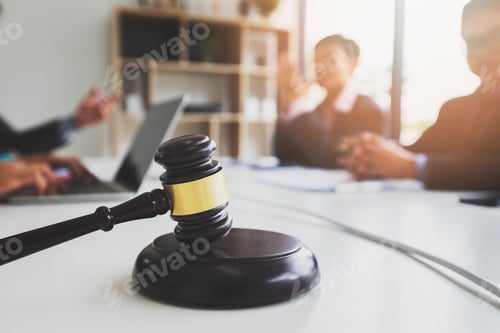 Preview: Wooden gavel on table in lawyer's office. Lawyer having team meeting with the client.