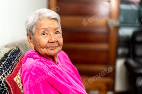 Preview: Elderly woman sitting comfortably at home, receiving geriatric care