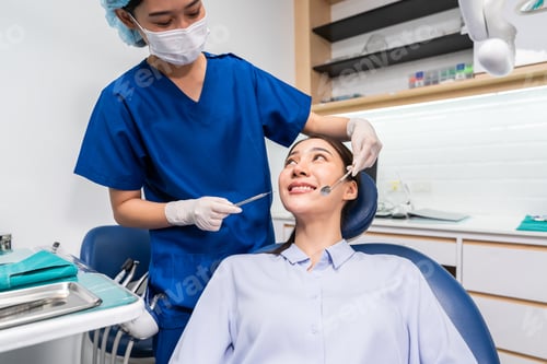 Preview: Asian dentist examine tooth to young girl at dental health clinic.