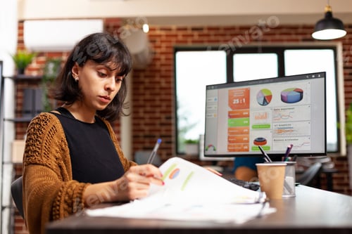 Preview: Businesswoman analyzing marketing graph working at company strategy in startup office