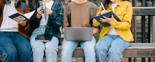 Preview: Young people college students is reading a book while relaxing sitting on grass in a campus park